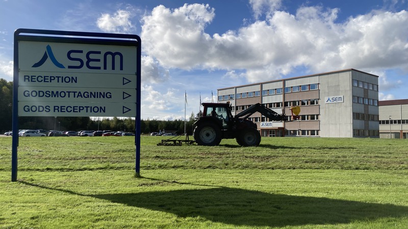 Traktor som harvar en gräsyta
