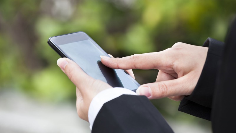 Person använder pekskärm på mobiltelefon