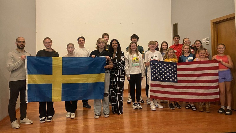 elever och lärare med en svensk och en amerikansk flagga